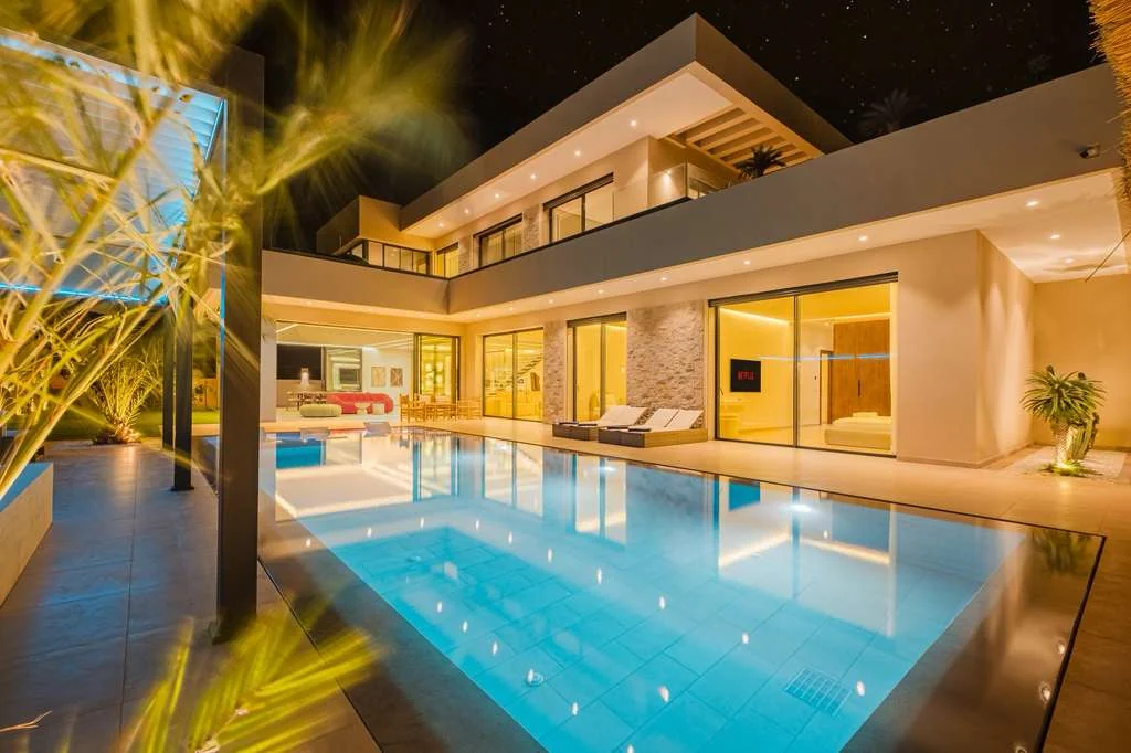 Façade contemporaine et piscine éclairée de nuit Route de l’Ourika