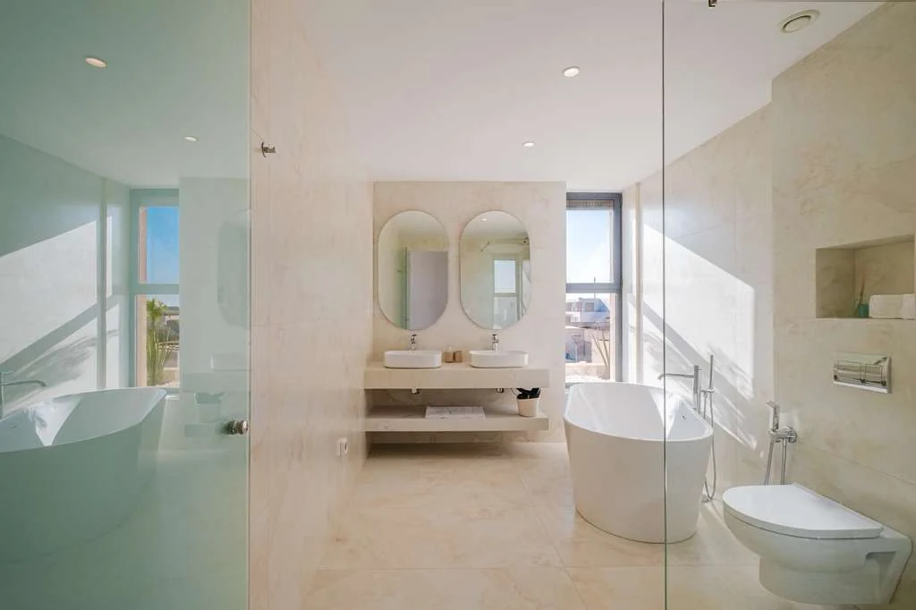 Salle de bain lumineuse avec baignoire et double vasque