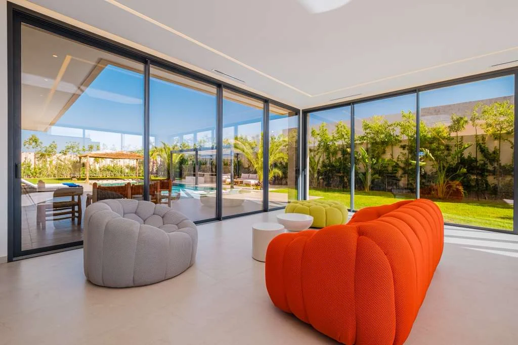 Salon panoramique ouvert sur le jardin et la piscine